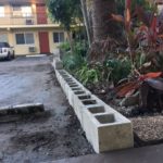Image of cement block foundation embedded against pavement.